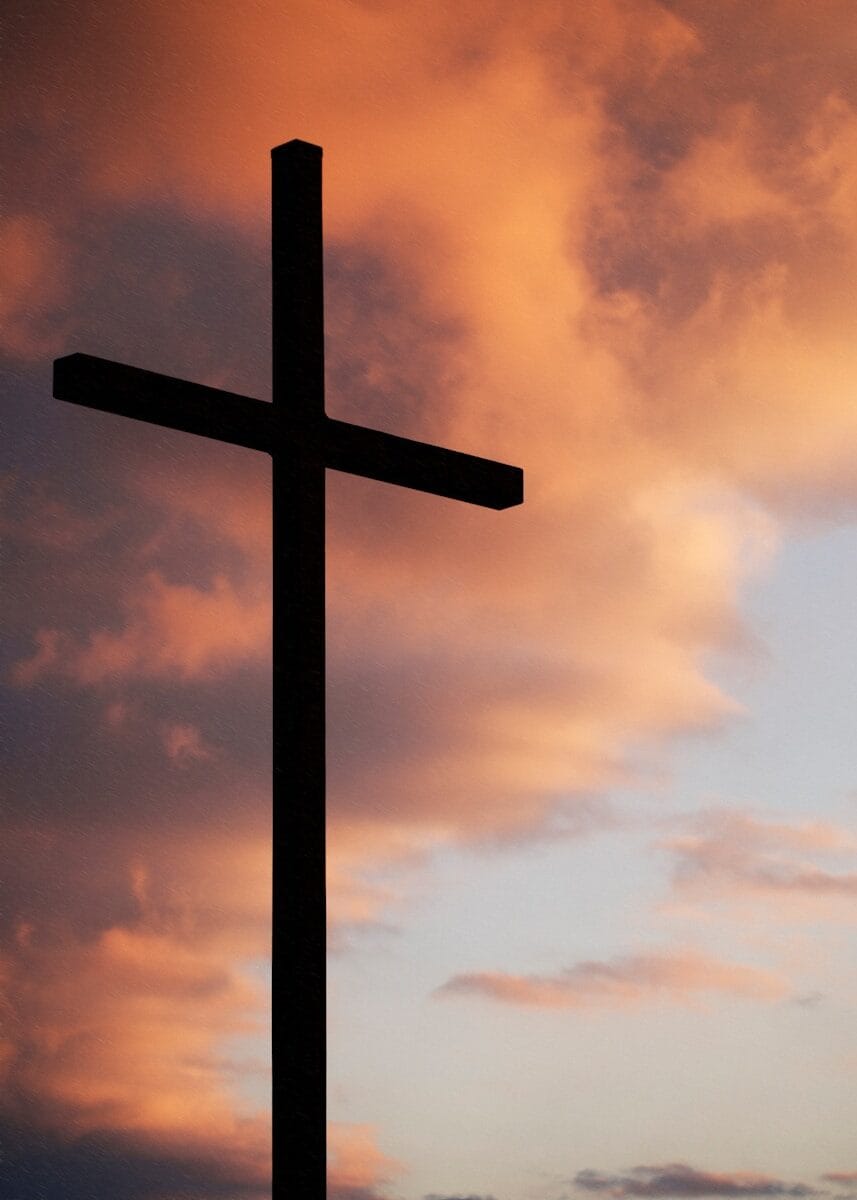 Photo by Aaron Burden silhouette of large cross under orange sky